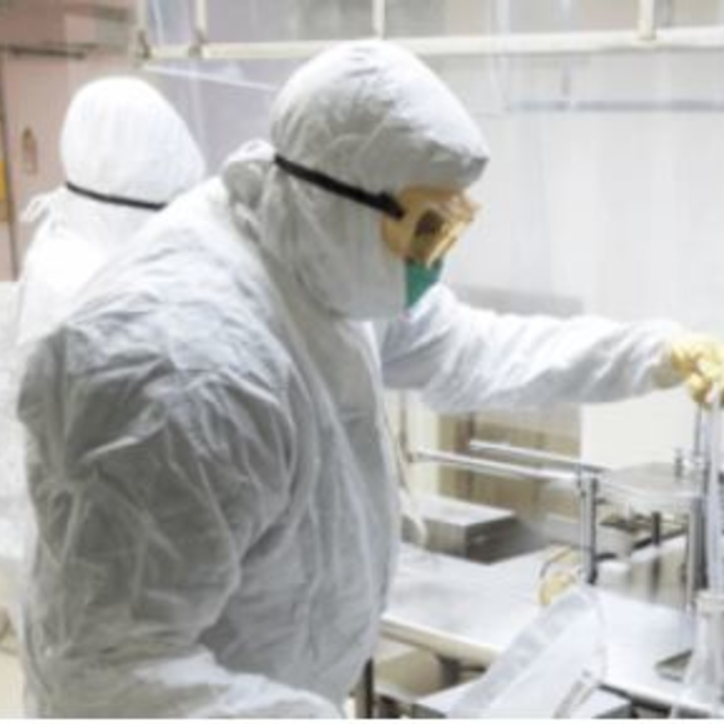 A staff member of UI Pharmaceuticals in sterile lab gear at work