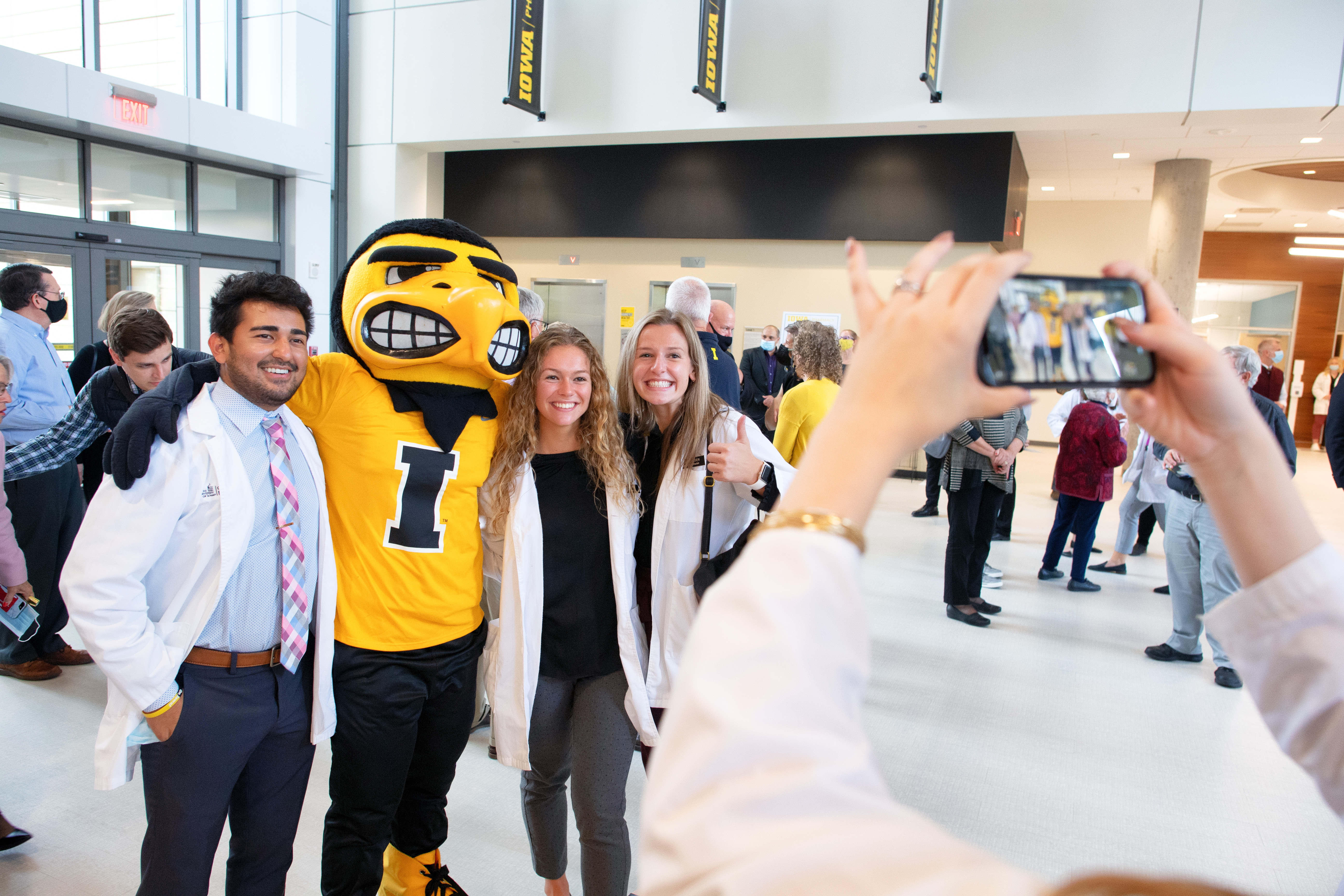 Herky the Hawk poses for a photo with students