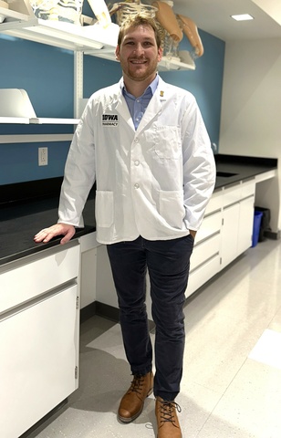 Austin Reutzel Standing in Lab with hand on counter