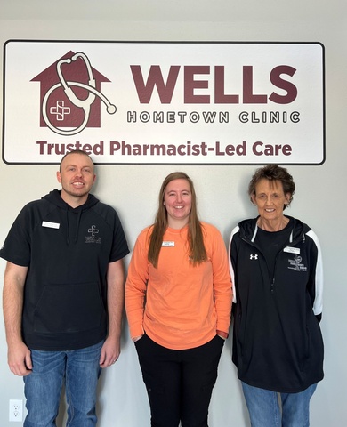 Staff members standing in front of the Wells Hometown Clinic sign.