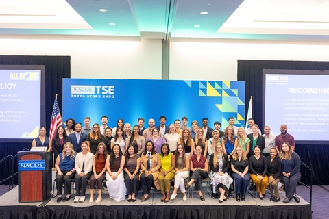Photo of a large group of students posing on a stage against a NACDS Total Store Expo backdrop.