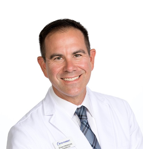 Chest-up headshot of Ryan Frerichs. He is wearing his white coat.