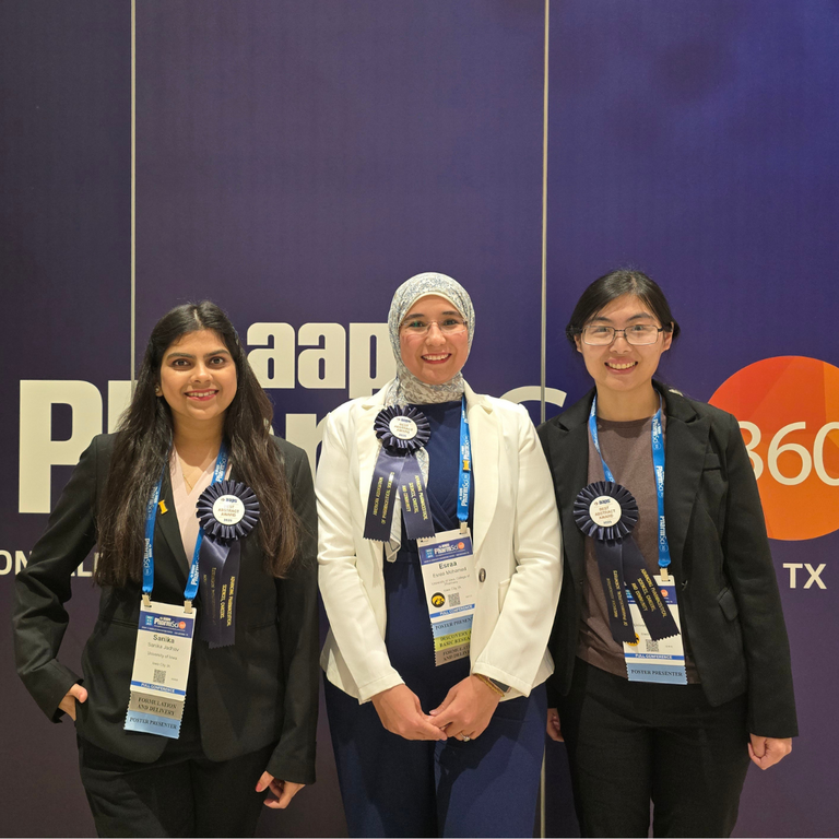 3 students post with best abstract award ribbons at a pharmaceutics conference