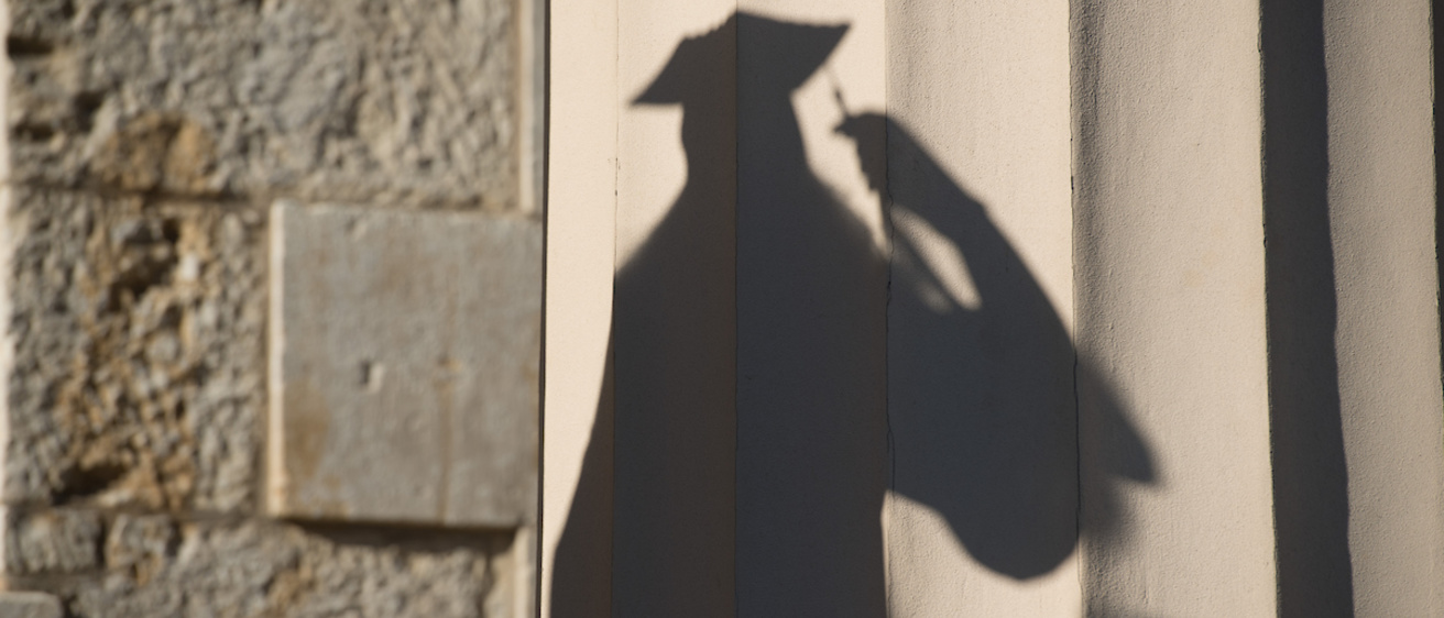 Shadow of person in cap and gown