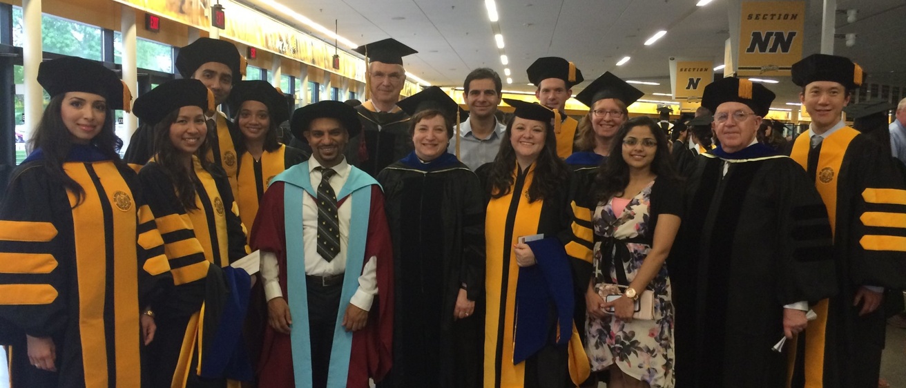 Posed photo of PhD graduates and faculty members at commencement