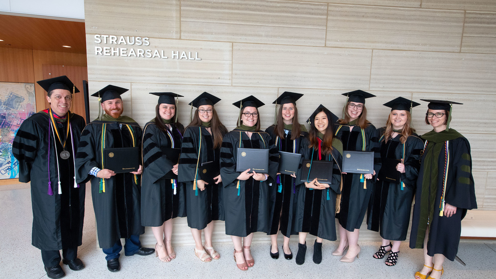 The first 8 PharmD students to graduate with a certificate in palliative care, at graduation with Drs. James Ray and Kashelle Lockman