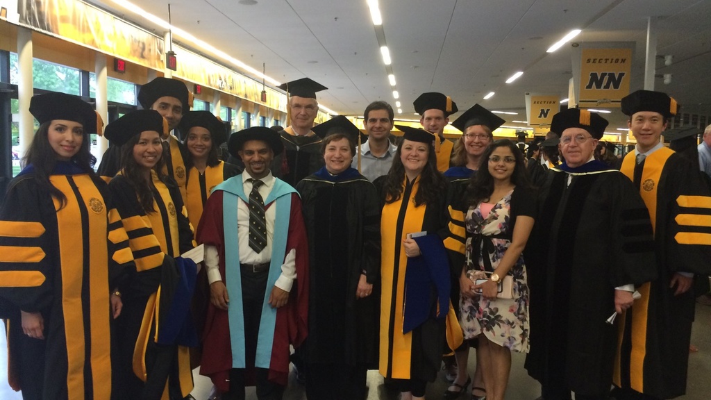 Posed photo of PhD graduates and faculty members at commencement